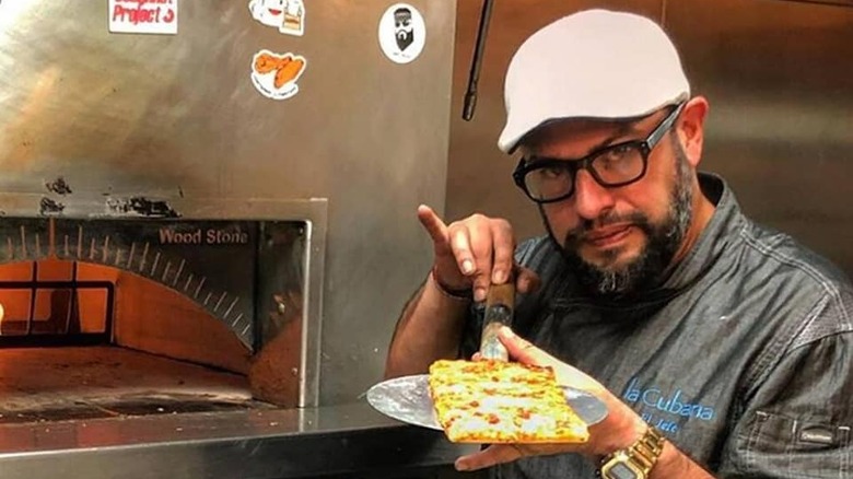 carl ruiz holding pizza