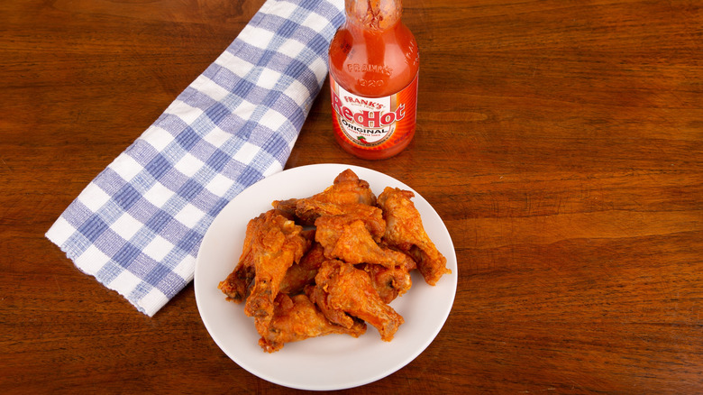 Bottle of Frank's and a plate of Buffalo wings