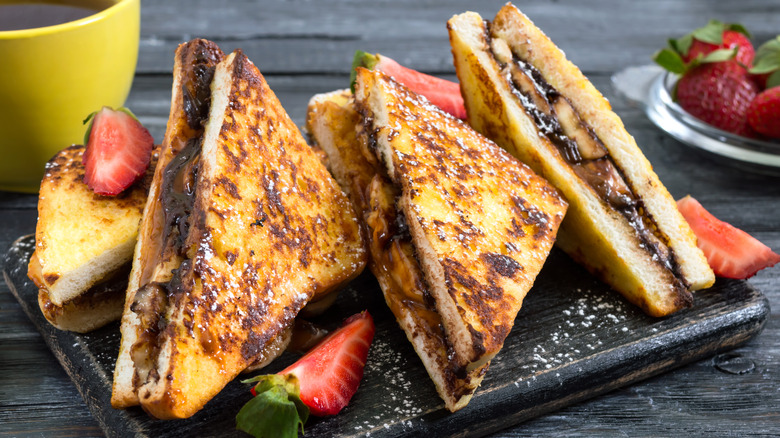 French toast stuffed with banana and chocolate served on black wood plate