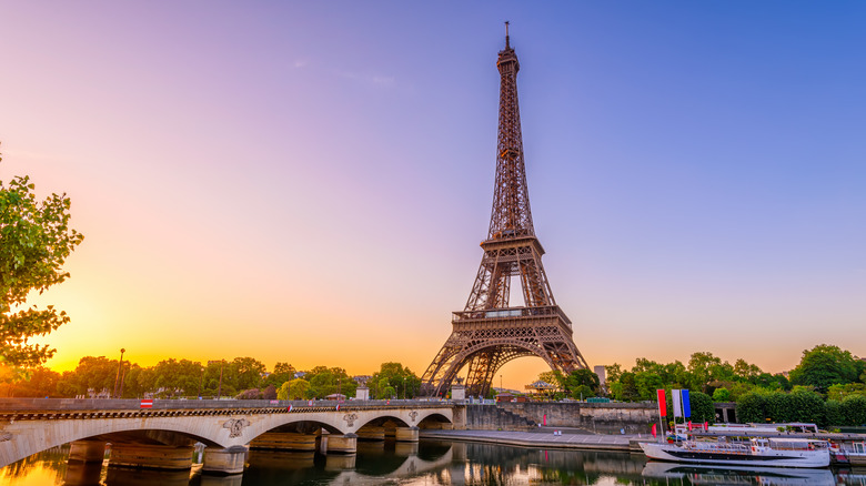 Eiffel tower in center set on sunset background 