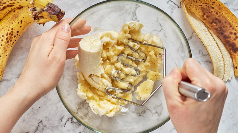 Glass bowl with bananas being mashed