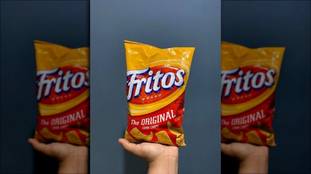 Holding a bag of Fritos 