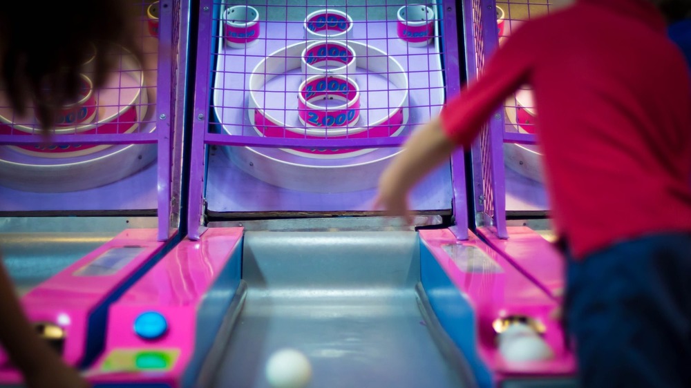 Children playing skeeball in a game arcade