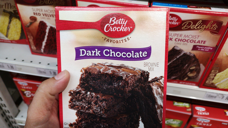 someone holding a betty crocker brownie box