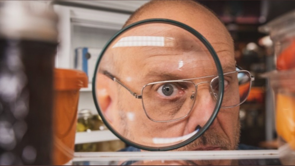 Alton Brown looking through magnifying glass