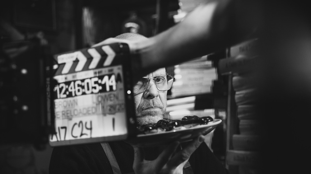 Alton Brown holding plate on Good Eats set