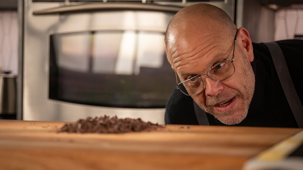 Alton Brown looking at chocolate on wooden cutting board