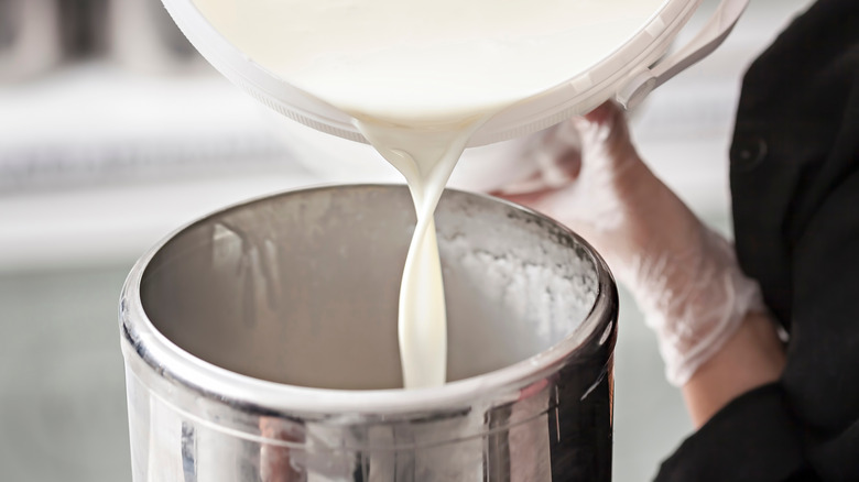 Worker pouring milk into container