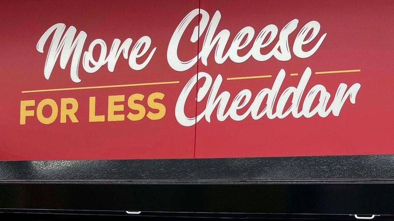 Grocery Outlet More Cheese for Less Cheddar sign