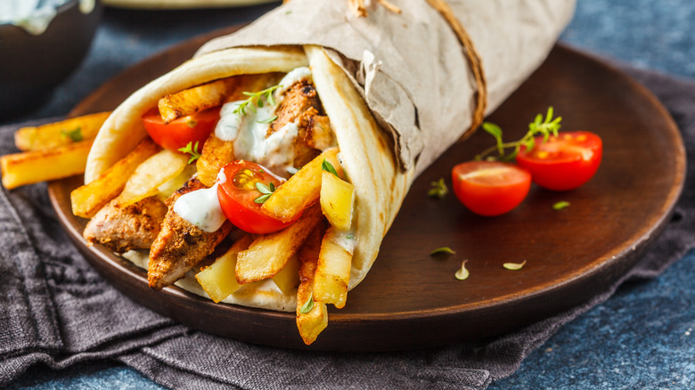 A gyro filled with french fries and tomatoes