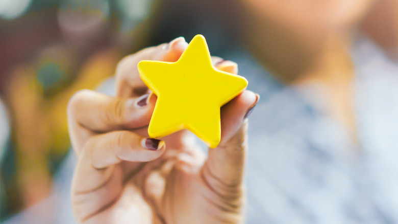 woman holding yellow star award