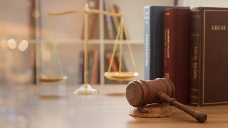 Judge's gavel next to a scale and books