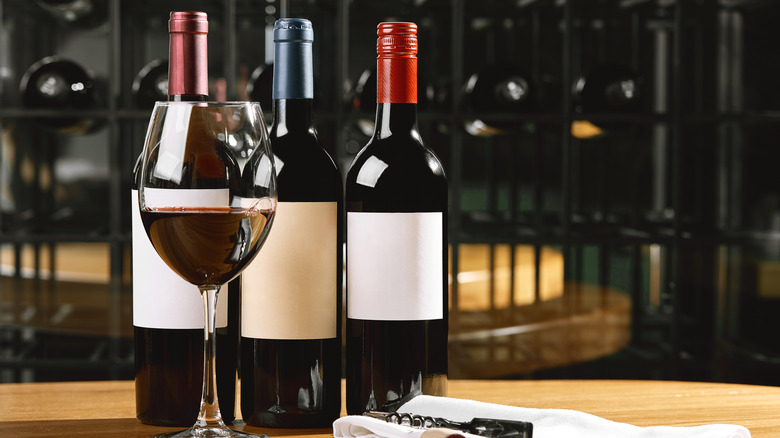 Wine bottles on table next to poured glass