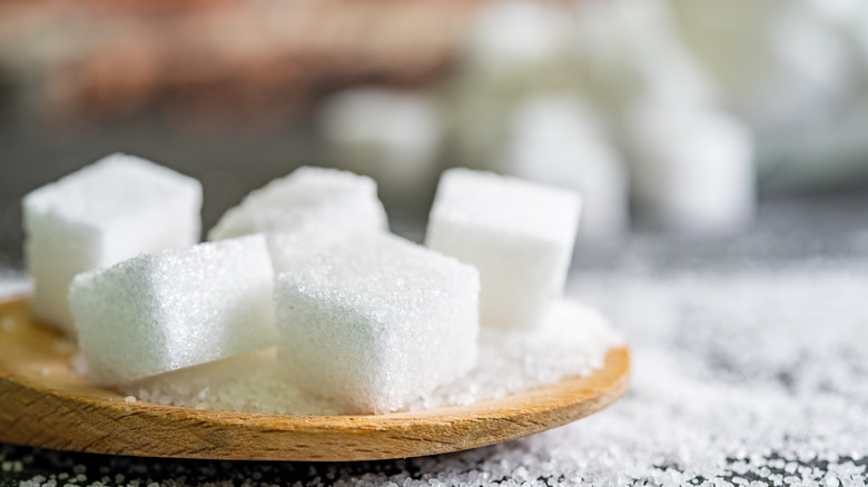 Sugar cubes on wooden plate 