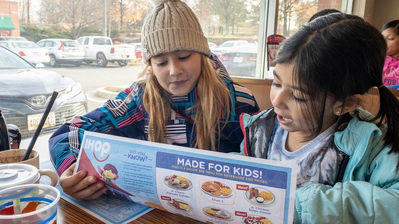 Kids reading an IHOP menu