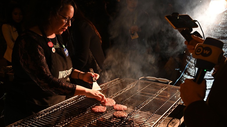 woman grilling impossible burgers