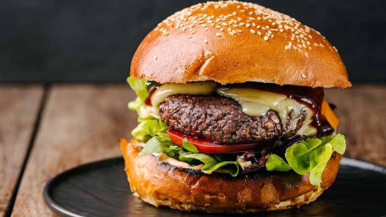 Impossible Burger with garnishes on black plate