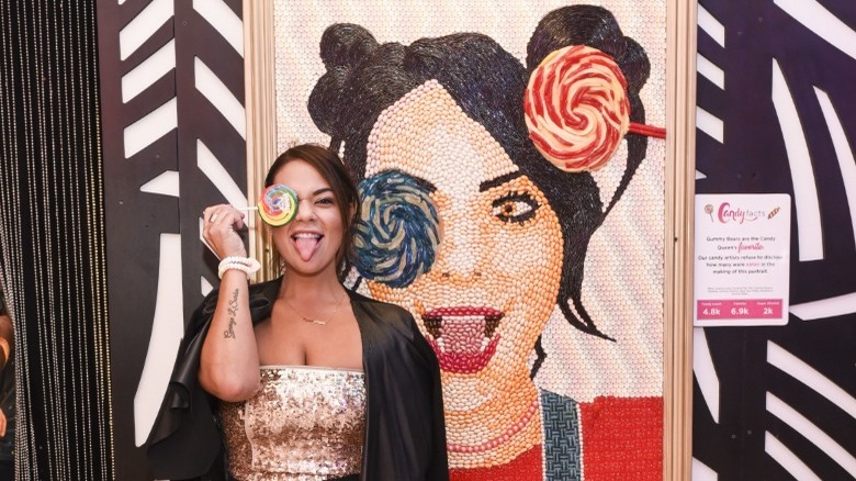 Sorkin posing in front of a candy portrait of herself