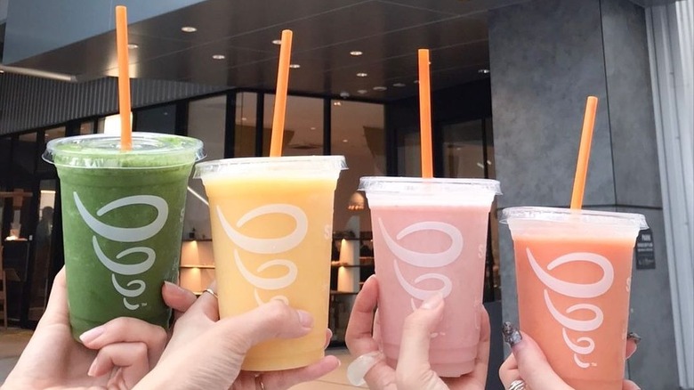four jamba smoothies lined up in hands outside