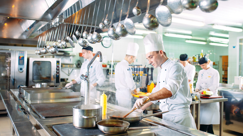 Chefs cooking in white in a kitchen