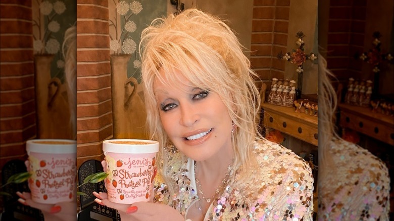 Dolly Parton holding a pint of Jeni's Strawberry Pretzel Pie ice cream