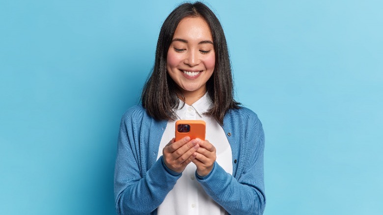 Person smiling at cell phone