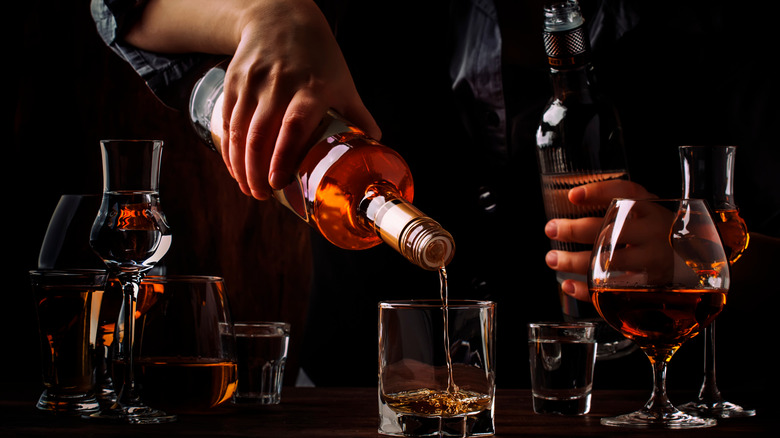 bartender pouring rum into tumbler