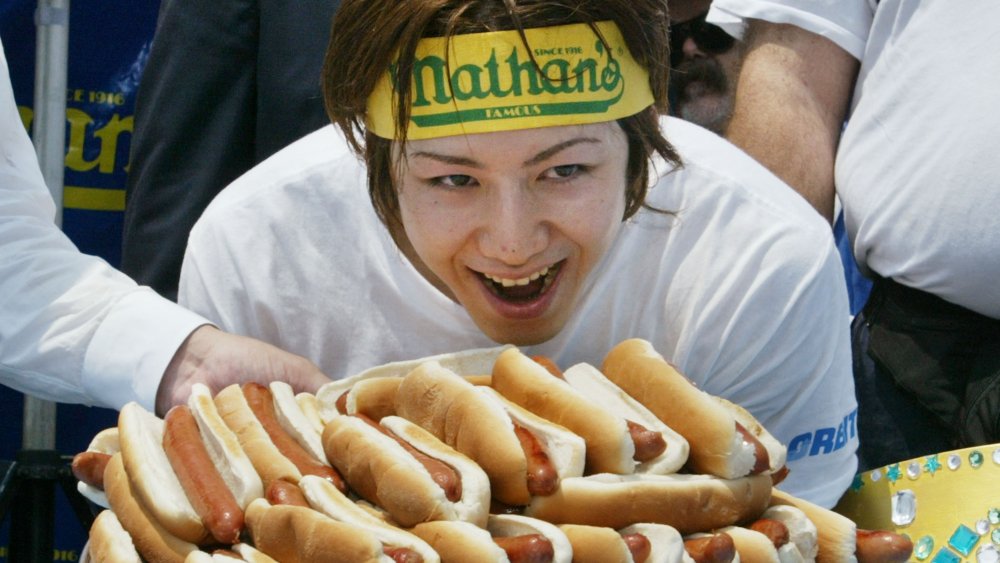 Takeru Kobayashi posing with hot dogs