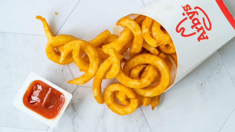 Arby's Curly fries spread on tile with ketchup 