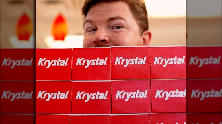 Man holding lots of Krystal boxes