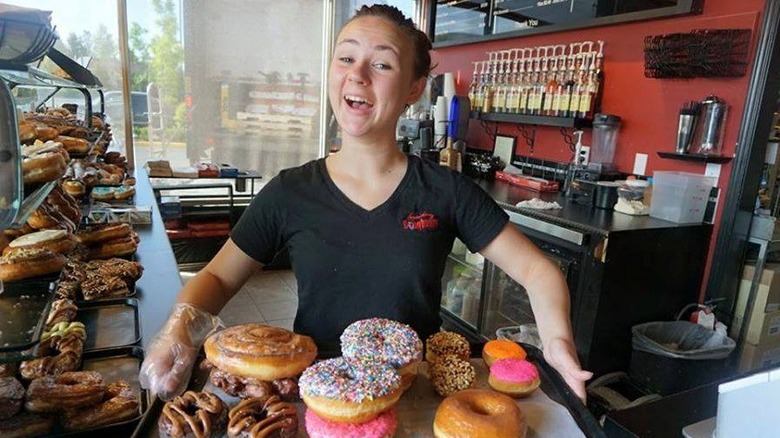 woman holding doughnut tray