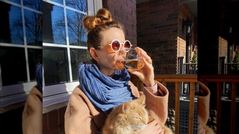 Mary Berg drinking wine and holding cat