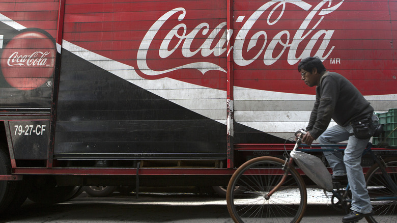 Cyclist passing Coca-Cola truck