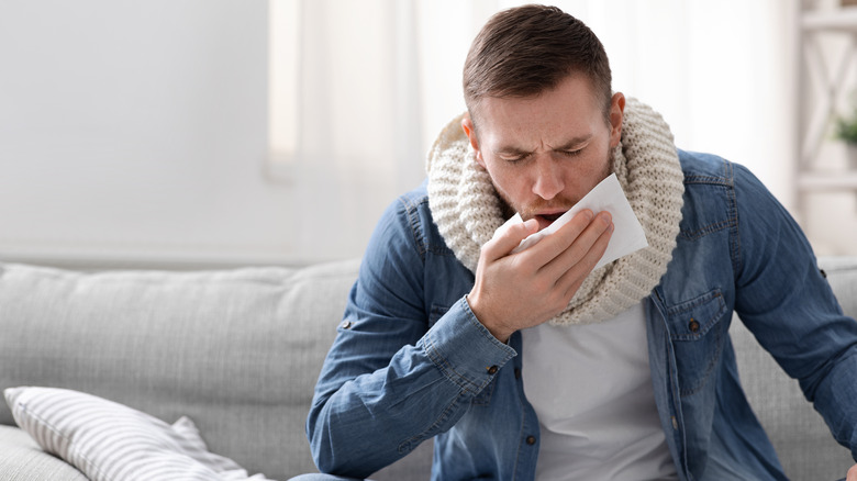 man coughing on couch