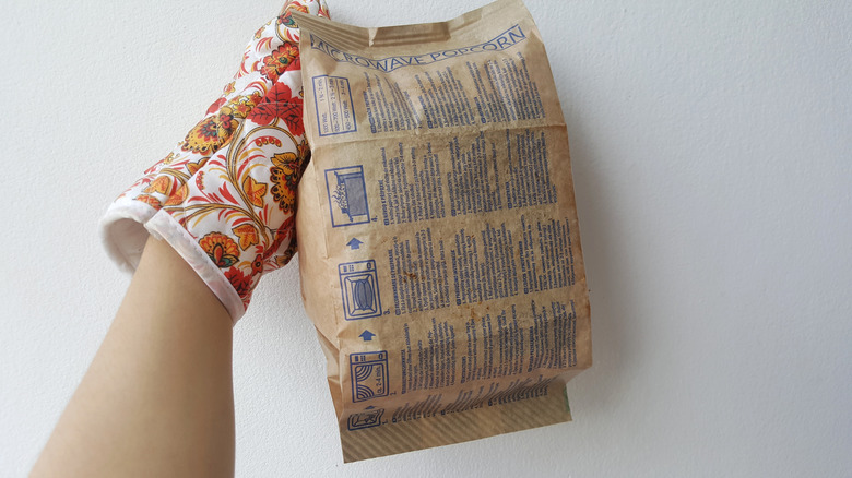 person holding bag of popcorn