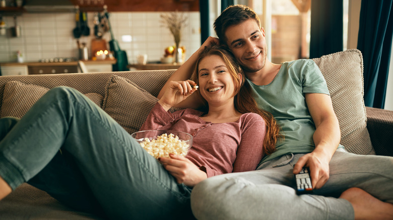 couple eating popcorn on couch