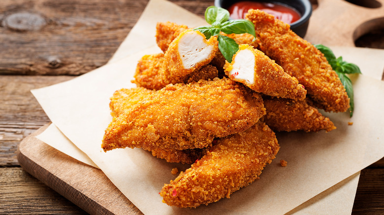 Chicken tenders on wooden board