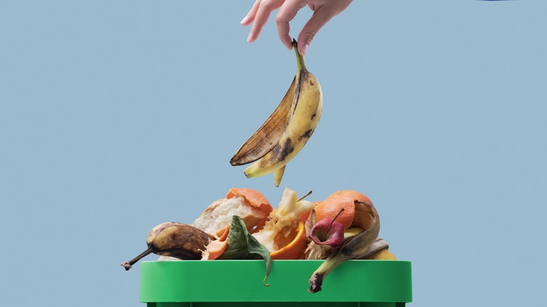 Banana peel being tossed into compost bin