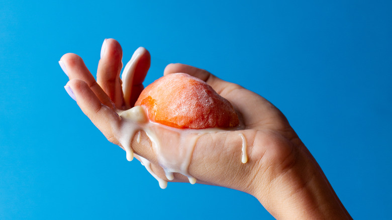 Hand holding a melting mochi ice cream 