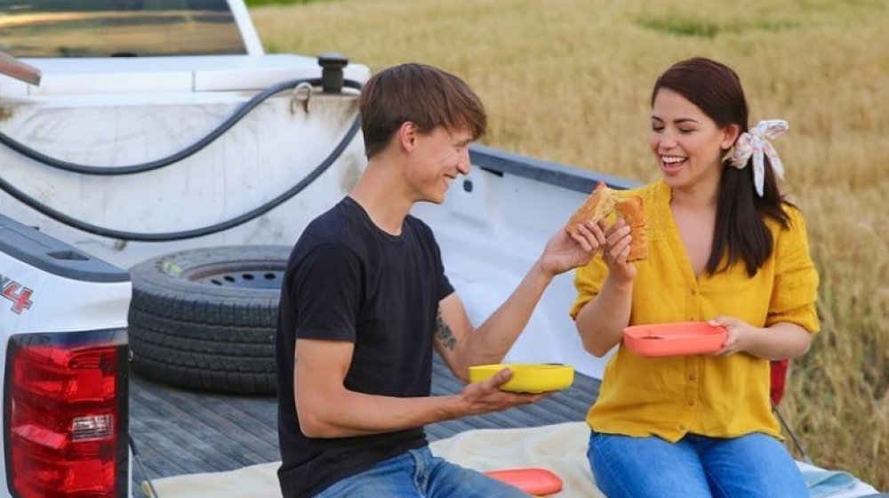 Yeh and her husband share a snack on the back of their pick up truck on the farm