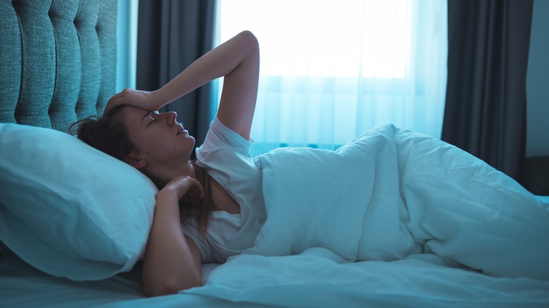 woman lying in bed with insomnia