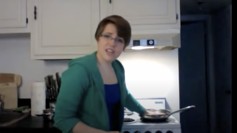 Hannah Hart in front of a stove