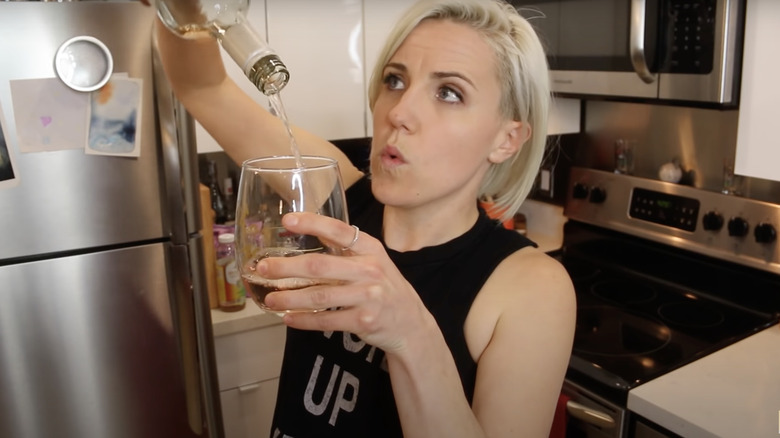 Hannah Hart pours white wine