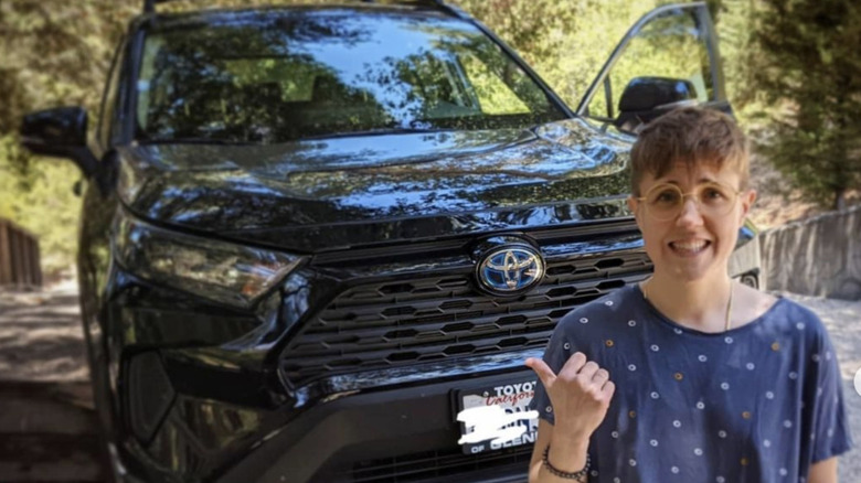 Hannah Hart in front of her car