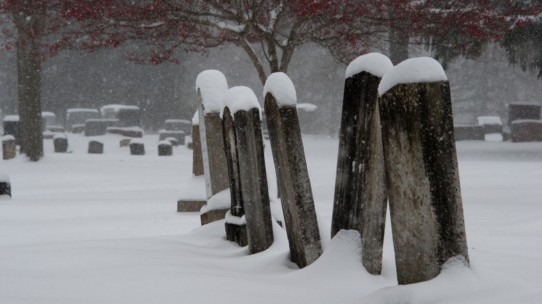 A snowy cemetery with headstones