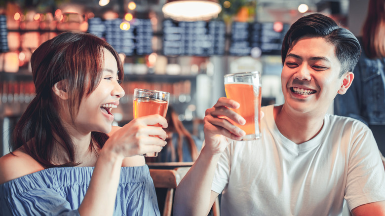 A laughing couple enjoying glasses of beer