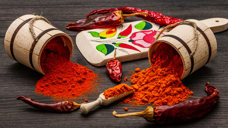 two types of paprika spilling out of wooden containers