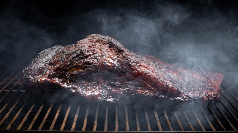 beef brisket smoking on a grill