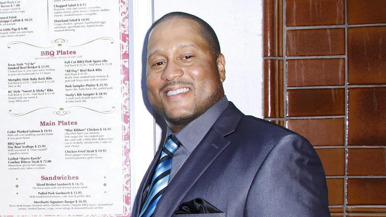 Pat Neely smiling with restaurant menu