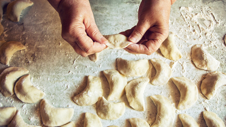 Person making batch of pierogi